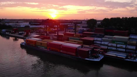Sonnenuntergang-Zur-Goldenen-Stunde-Im-Hafen-Von-Alblasserdam-In-Den-Niederlanden-Mit-Containerschiff,-Das-Zum-Laden-Verankert-Ist