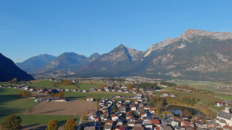 Soothing-morning-flyover-down-towards-village-in-Tirol-Austria,-drone-lower-shot
