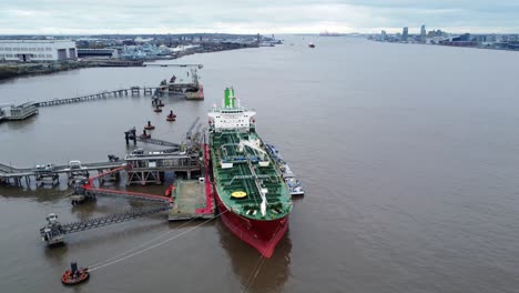 Silver-Rotterdam-oil-petrochemical-shipping-tanker-loading-at-Tranmere-terminal-Liverpool-aerial-descending-left-tilt-up-view