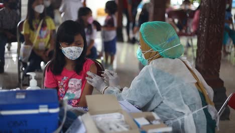 Yogyakarta,-Indonesia---Dec-20,-2021-:-an-elementary-school-girl-is-receiving-the-covid-19-vaccine