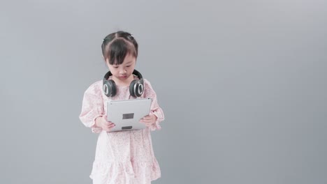 Child-with-headset-watching-videos-with-digital-tablet