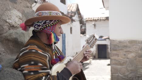 Native-street-performer,-busker,-plays-the-charango-in-Cuzco,-Peru,-medium-shot