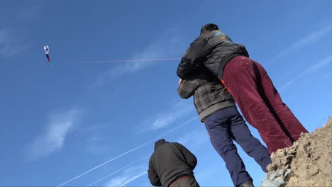 Young-Afghan-refugees-play-with-a-handmade-kite-on-the-edge-of-the-makeshift-camp-in-Calais-known-as-the-Jungle-on-a-clear-but-cold-winter’s-day