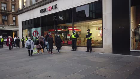 Shoppers-walk-past-a-line-of-police-officers