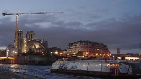 Notre-dame-reconstruction-and-repair-behind-Seine-river-boat-tour-for-tourists-4k-60p