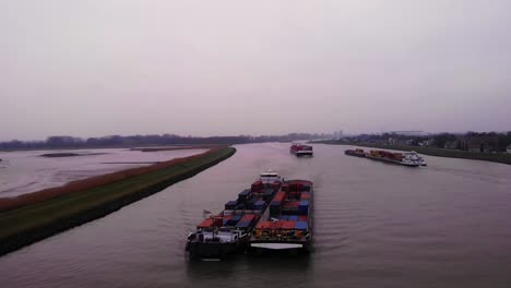 Aerial-View-Of-Maas-Cargo-Ship-Paired-With-Another-Carrying-Containers-On-River-Noord-On-Cloudy-Afternoon