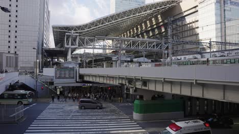 Osaka-Jr-Umeda-Station,-Zug-Kommt-An,-Während-Leute-Am-Kreuzweg-Warten