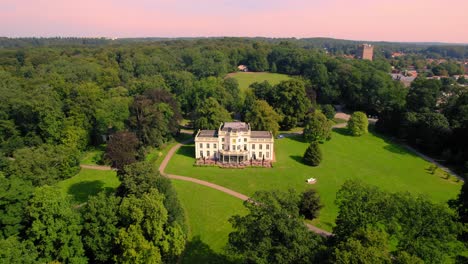 Aerial-Over-Manor-House-In-Veluwe-National-Park-With-Pan-Reveal-Over-Urban-City-In-Netherlands