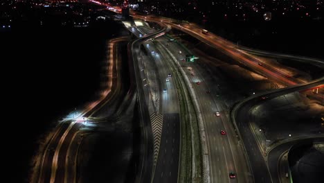 Top-down-night-city-roads-with-cars-driving-aerial-view