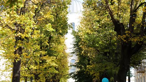 Dome-of-Soboras-behind-autumn-tree-lines-of-Freedom-Alley-in-Kaunas,-static-sunny-day-shot