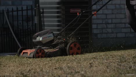 Slow-motion-of-an-electric-mower-being-pushed-in-a-backyard