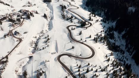 Drone-shot-along-beautiful-winding-mountain-road-along-side-a-ski-slope