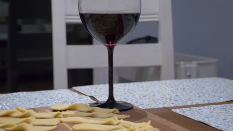 Twisted-Faworki-Dough-On-The-Table-With-Glass-Of-Red-Wine-On-Side