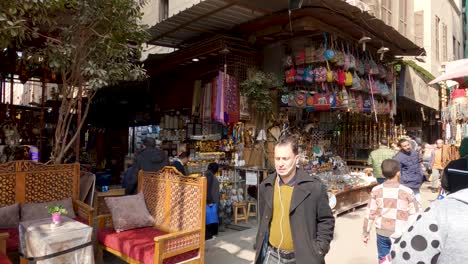 People-on-Cairo-bazaar-street,-shops-and-stores-selling-craft-during-daytime,-Egypt