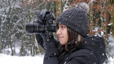 Beautiful-female-take-photos-of-snowfall-in-forestry-area,-close-up-view