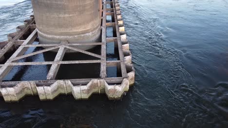 Slow-motion-shot-of-Chattanooga-TN,-Chickamauga-Dam-Rail-Road-Bridge-Pylon-water-flowing-on-a-fresh-morning-in-USA