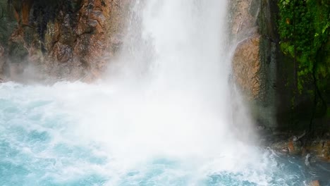 Close-up-footage-of-the-massive-amounts-of-water-crashing-down-in-a-beautiful-turquoise-pool