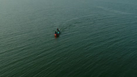 Aerial-shot-of-Speeding-Patrolling-Boat-At-Keenjhar-Lake-In-Thatta,-Pakistan-at-sunset