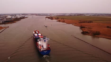 Aerial-View-Of-Stern-of-JSP-Carla-Cargo-Ship-Travelling-Along-Oude-Maas-On-Overcast-Day