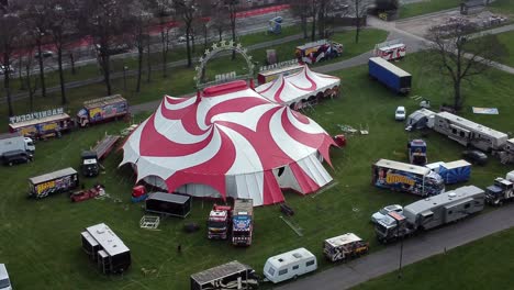 Planet-circus-daredevil-entertainment-colourful-swirl-tent-and-caravan-trailer-ring-aerial-rising-track-down-view