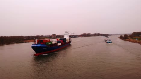 Aerial-Drone-Shot-Of-JSP-Carla-Cargo-Ship-Travelling-Along-Oude-Maas-On-Overcast-Day