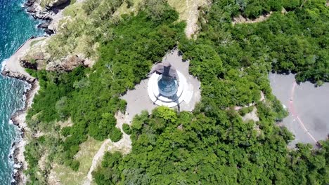 A-birds-eye-view-of-the-popular-tourism-landmark-Cristo-Rei-statue-and-surrounding-greenery-and-rugged-shoreline-in-capital-Dili,-Timor-Leste