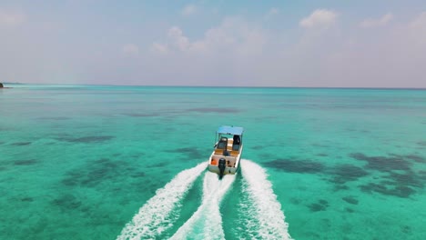 Das-Boot-Segelt-Auf-Der-Türkisfarbenen-Wasseroberfläche-Der-Malediven-In-Der-Nähe-Der-Insel,-Dazu-Braucht-Es-Grüne-Bäume