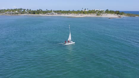 Barco-Navegando-En-El-Caribe-Azul-Justo-Al-Lado-De-La-Playa-Bordeada-De-Palmeras