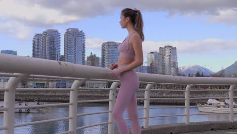 Model-woman-posed-in-athletic-clothes-with-Vancouver-BC-City-Skyline,-Wide-Shot