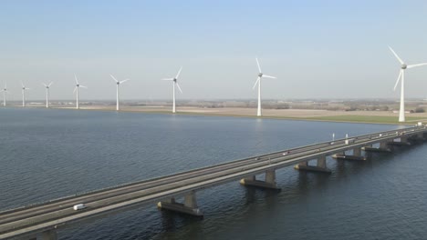 Flyover-along-Ketelbrug-bridge-over-lake,-windmills-in-lake-shore