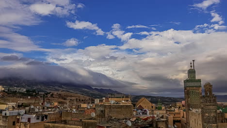 White-cloud-movement-in-timelapse-over-the-Koutoubia-Mosque-and-Jemaa-el-Fna-square,-Morocco-on-a-bright-sunny-day