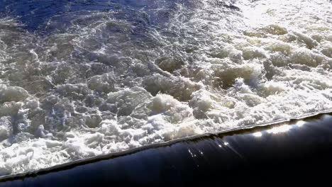 Langsamer-Blick-Nach-Unten-über-Das-Wasser,-Das-über-Die-Überlaufrinne-Auf-Dem-Fluss-Tapia-Fließt