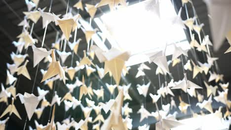 Paper-cranes-hanging-from-a-ceiling-with-a-skylight