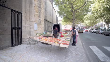 Farmer's-market-with-buyers-receiving-a-bag-of-produce-in-front-of-the-St