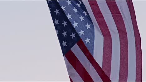 SLOW-MOTION:-Close-up-of-an-American-flag-as-the-camera-slowly-tilts-down,-revealing-a-ragged-edge-at-the-bottom