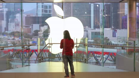 Ein-Apple-mitarbeiter-Steht-Vor-Dem-Apple-logo-Des-Amerikanischen-Multinationalen-Technologieunternehmens-In-Dessen-Offiziellem-Geschäft-In-Hongkong