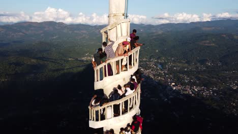 Crane-Shot-Of-People-Climbing-The-Stairs-On-Ambuluwawa-Tower,-Beautiful-Landscape-Background,-Gampola,-Sri-Lanka
