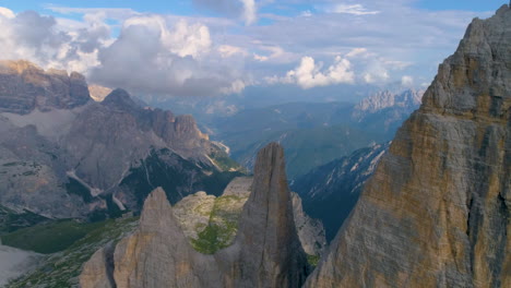 Slow-tilt-down-aerial-above-Tre-Cime-South-Tyrol-extreme-valley-mountain-summit-rock-formation
