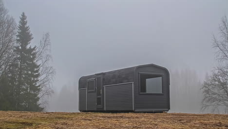Static-shot-of-fog-passing-with-the-view-of-a-wooden-cabin-throughout-the-day-in-timelapse