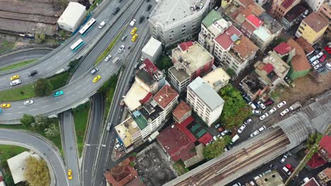 Aerial-top-down-view-of-yellow-taxi-cabs-crossing-a-interconnected-highway-loop-surrounded-by-old-European-buildings-in-Istanbul-Turkey-on-a-cloudy-day