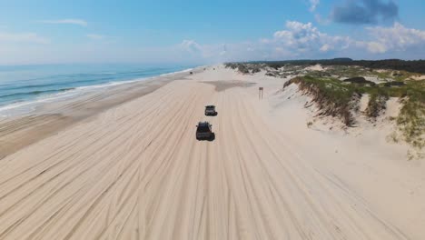 Drone-following-black-suv-and-silver-truck-on-Outer-Banks-Corolla-4x4-beach
