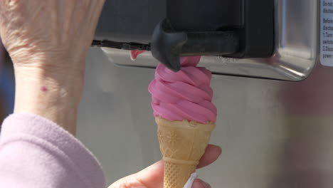 Super-slow-motion-shot-of-female-ice-cream-vendor-preparing-pink-soft-ice-cream-in-summer