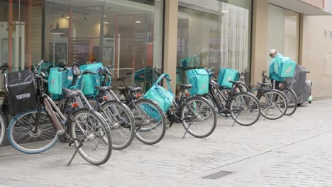 Deliveroo-food-boxes-with-bicycles-on-city-street-outside-the-restaurant-in-Brussels,-Belgium