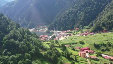aerial-drone-flying-over-a-large-mountain-forest-hill-revealing-a-beautiful-lake-and-mosque-in-the-village-of-Uzungol-Trabzon-Turkey-on-a-sunny-summer-day