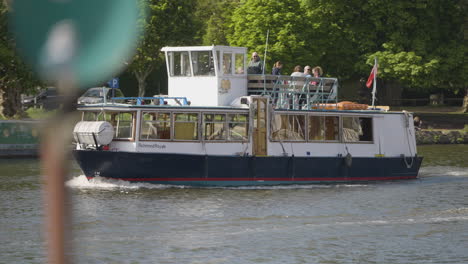 Passenger-boat-sailing-on-river-Thames-near-Kingston,-camera-follow-view