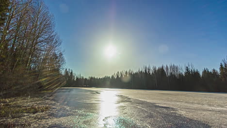 Time-lapse-shot-of-frozen-lake-melting-after-golden-sunrise-in-the-morning-and-purple-sunset-in-the-evening