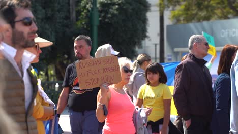 Woman-holding-up-expletive-sign-against-Putin-at-anti-war-rally