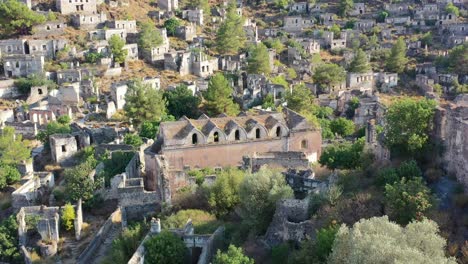 aerial-drone-circling-onto-an-abandoned-greek-orthodox-church-in-the-ghost-town-village-of-Kayakoy-in-Fethiye-Turkey-on-a-sunny-summer-day