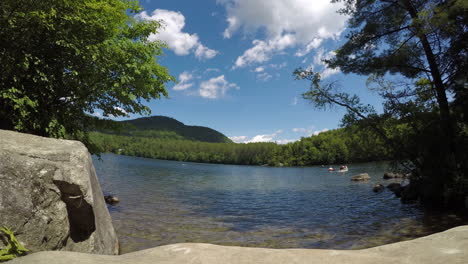 Beautiful-Mirror-Lake-in-the-state-of-Maine,-panoramic-time-lapse-footage-in-spring-with-fast-moving-clouds-against-a-clear-blue-sky