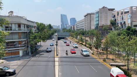 Timelapse-Of-Traffic-Along-Highway-And-Underpass-Tunnel-With-Shopping-Centre-Torre-Manacar-In-Background
